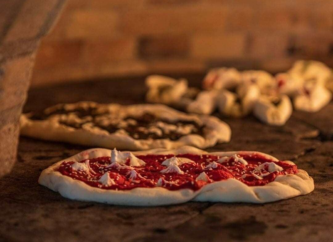 Pizza in oven with red sauce