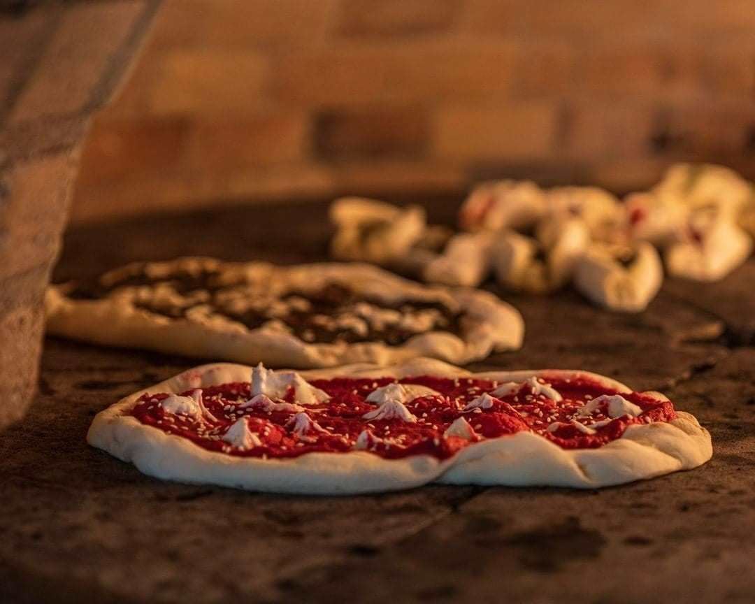 Pizza in oven with red sauce